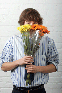 man with flowers covering his face