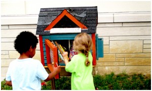kids taking books from little free library
