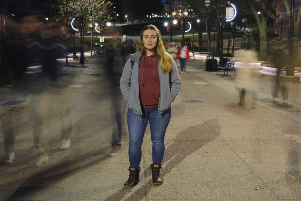 First-gen student stands still while other students pass by