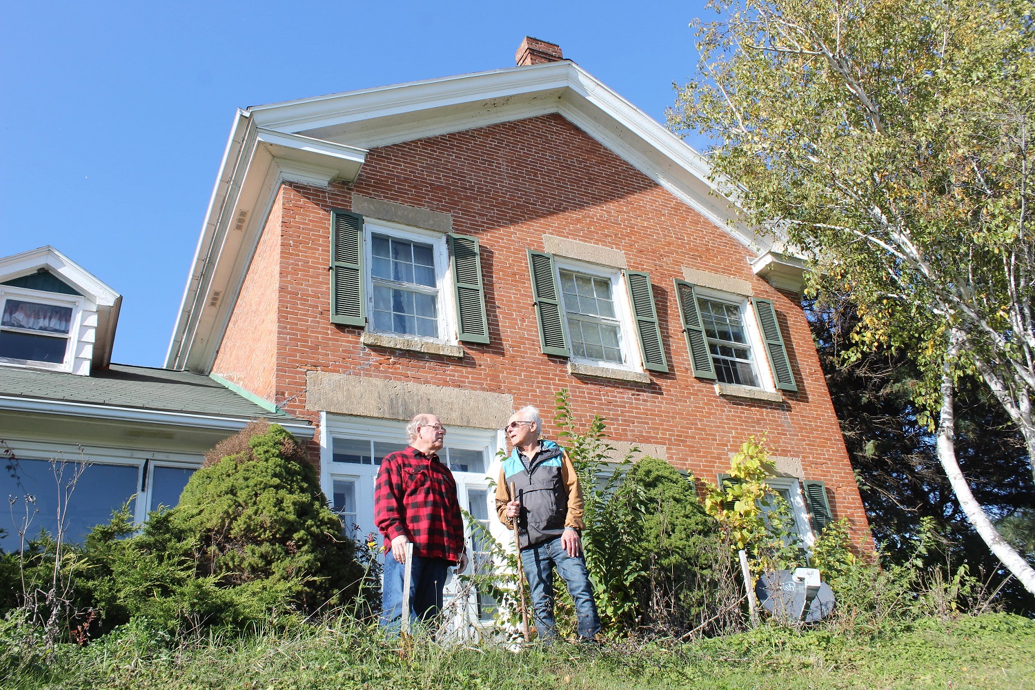 Chase and Klein stand in front of the historic Thompson-Schneider home