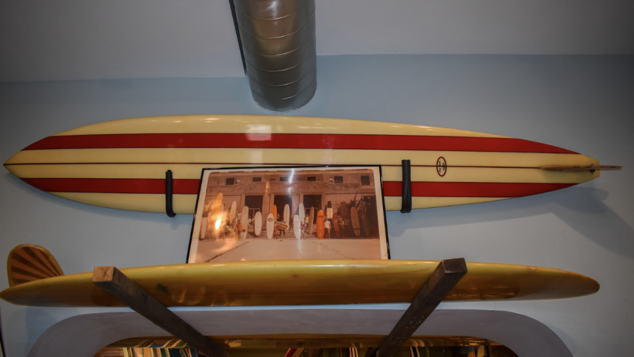 A photo is displayed of a group of surfers, including Larry and Lee Williams and Teek, in front of the Sheboygan County courthouse in the 1960s.